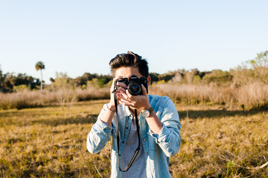student taking photos in a field